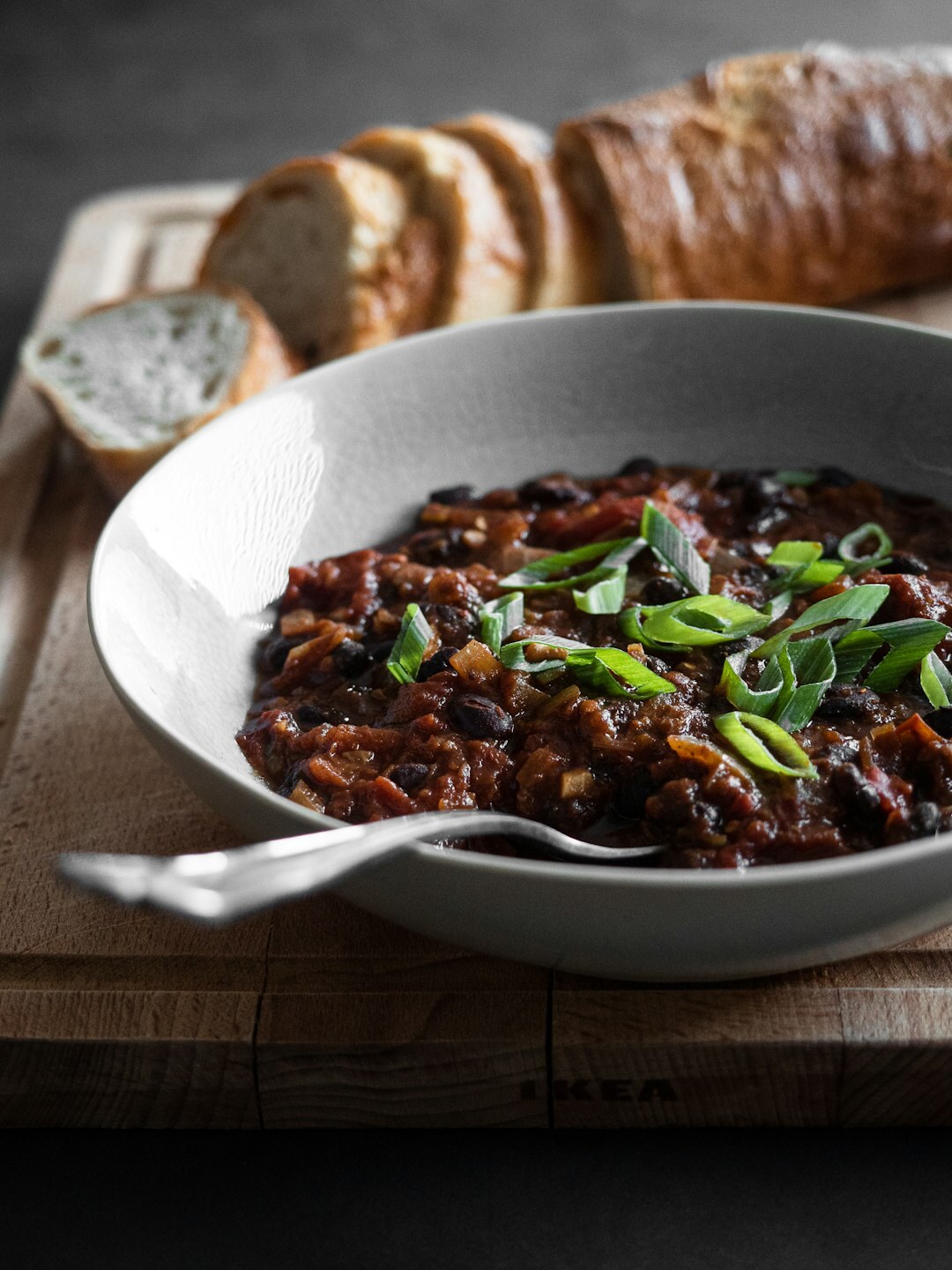 Bowl of Czech goulash with bread on wooden table